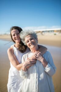 senior mom and daughter on beach