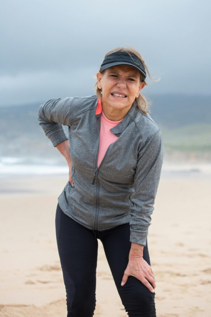 woman experiencing back pain as symptom of heart attack